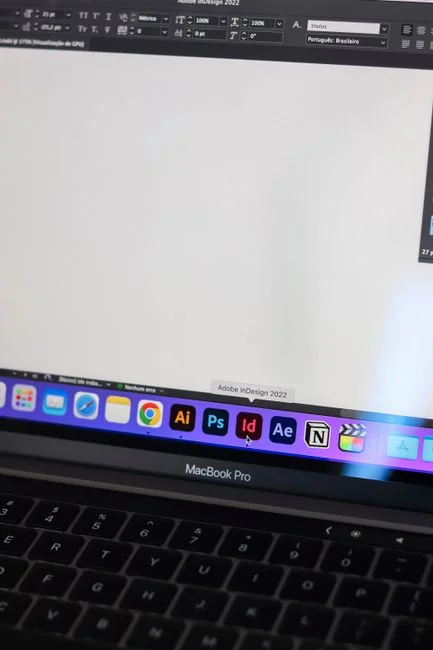 A laptop on a bed showing web design software, creating a cozy workspace.